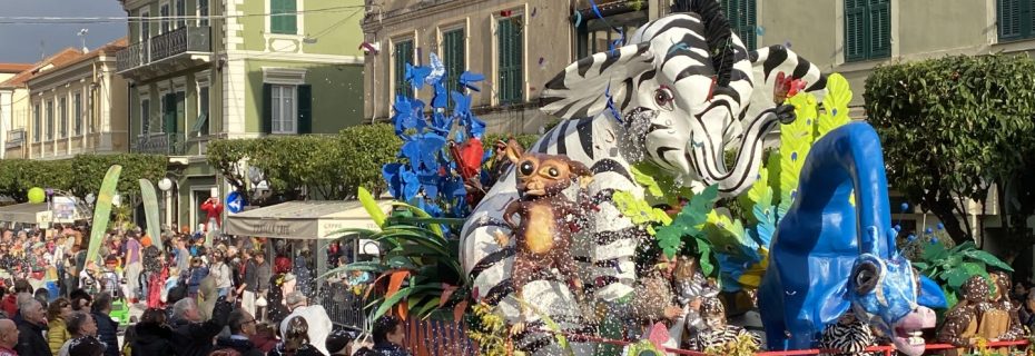 Carnevale in Liguria: sfilata con carri colorati e decorazioni a tema, persone in costume tra la folla, atmosfera festosa.